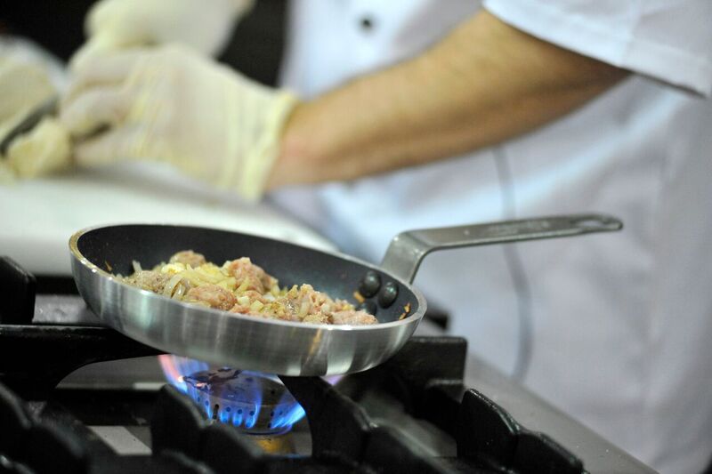 chef cooking in small pan over hob